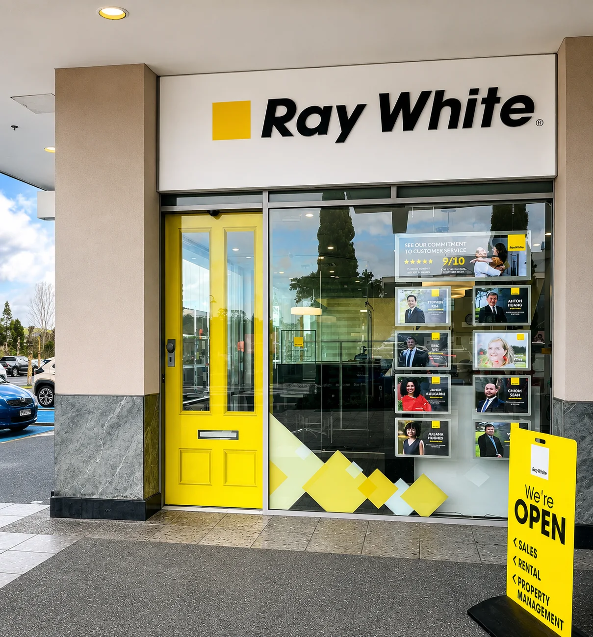 Ray White Botany storefront with yellow entrance graphic and OPEN wayfinding board